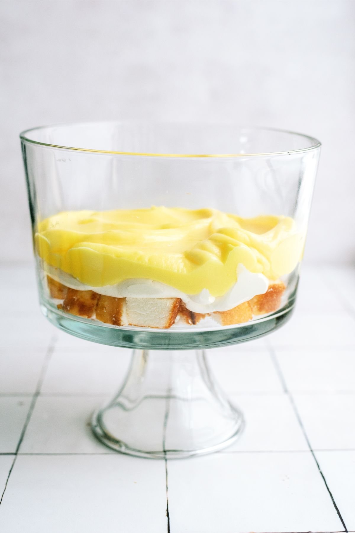 Lemon pudding mixture on top of cream cheese mixture in trifle dish