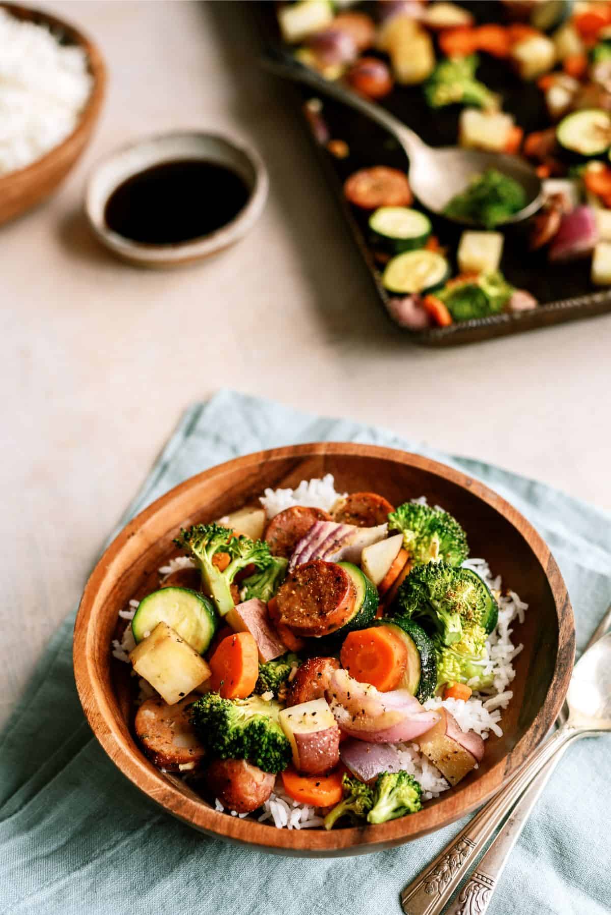 A serving of One Pan Garlic Sausage and Vegetables in a bowl with utensils 