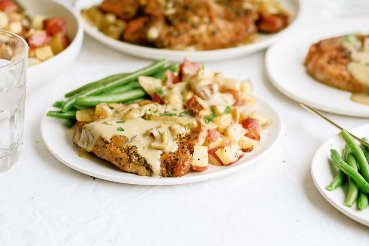 Slow Cooker Pork Chops and Gravy on a plate with green beans and potatoes