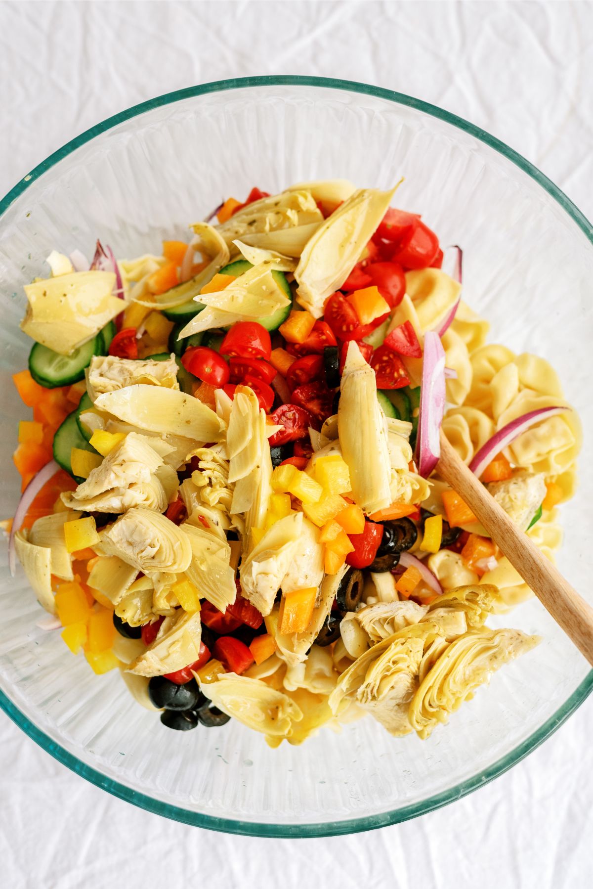 Combining ingredients for Tortellini Pasta Salad in a large bowl
