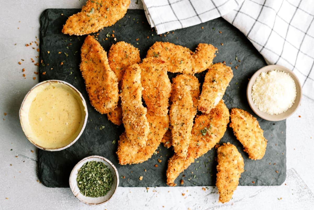 Baked Panko Chicken on a cutting board with sauce on the side