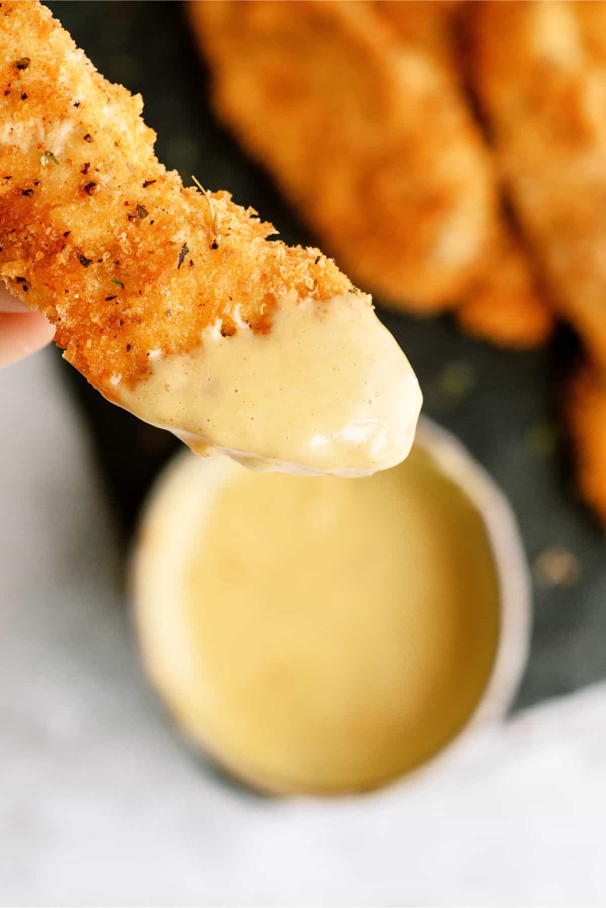 One Baked Panko Chicken being dipped in sauce