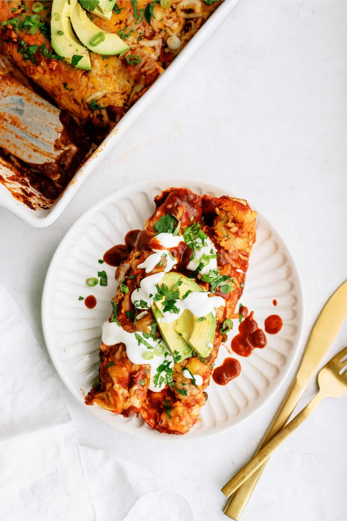 Two Chicken Fiesta Enchiladas on a plate with toppings