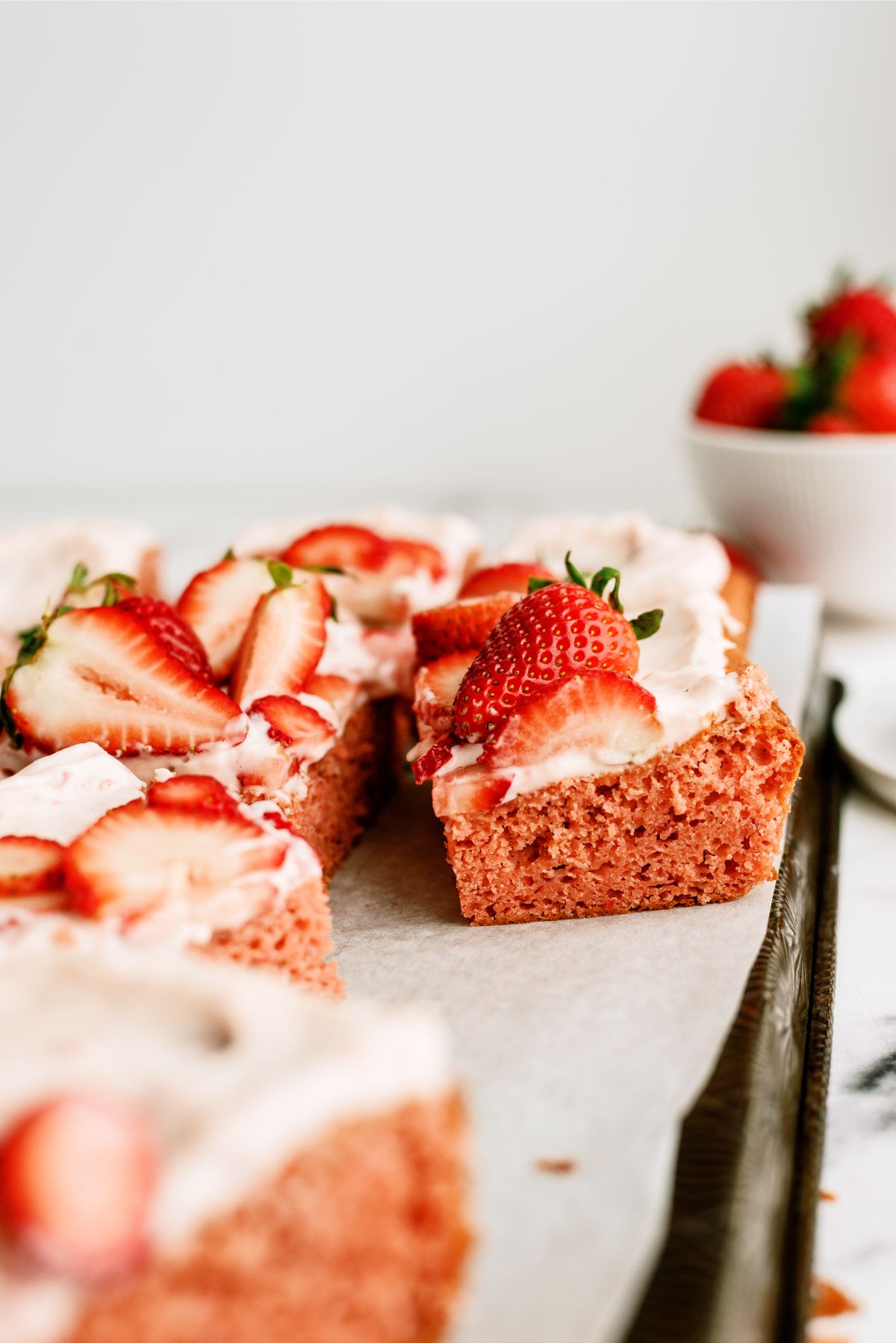 Frosted Strawberry Sheet Cake cut into squares