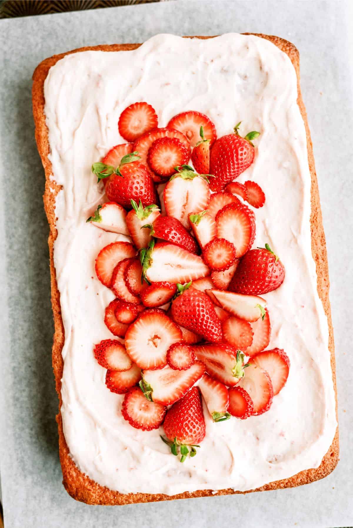 Frosted Strawberry Sheet Cake topped with fresh strawberries.