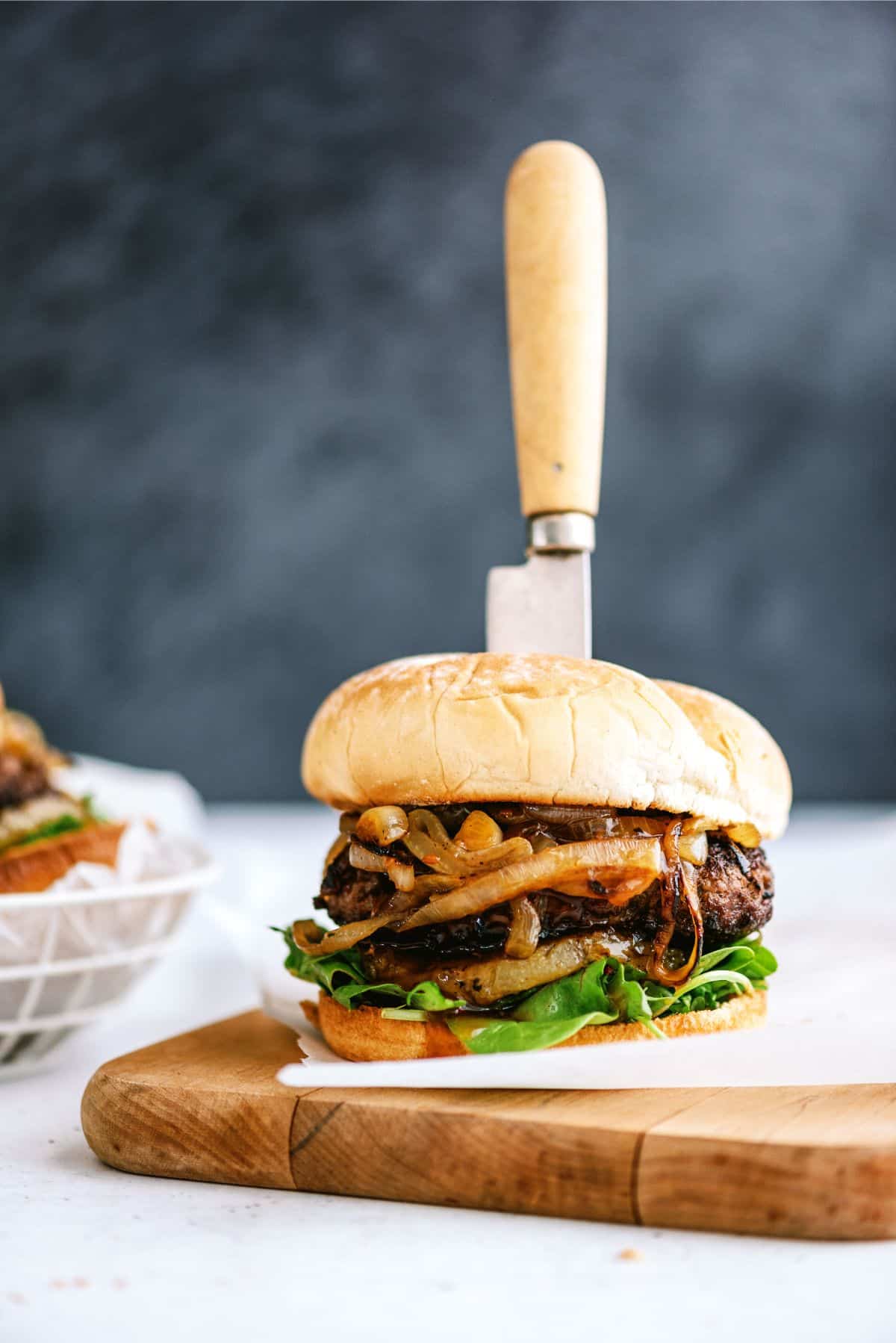 Grilled Teriyaki Burger with a knife in the middle of it.