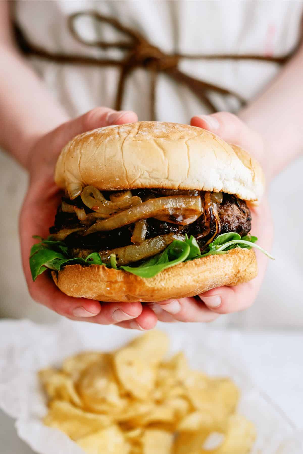 Holding a Grilled Teriyaki Burger with toppings