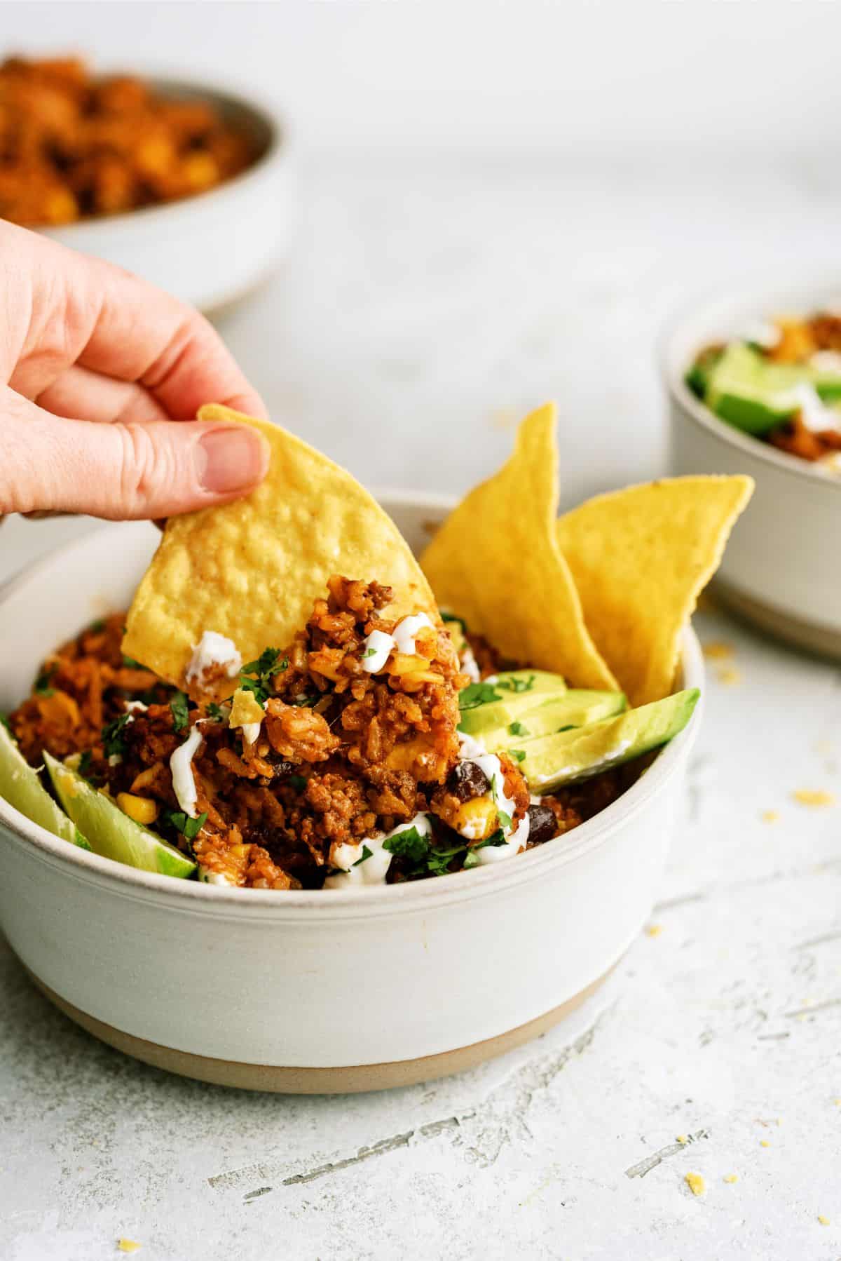 Eating out of Instant Pot Ground Beef Burrito Bowl with chips