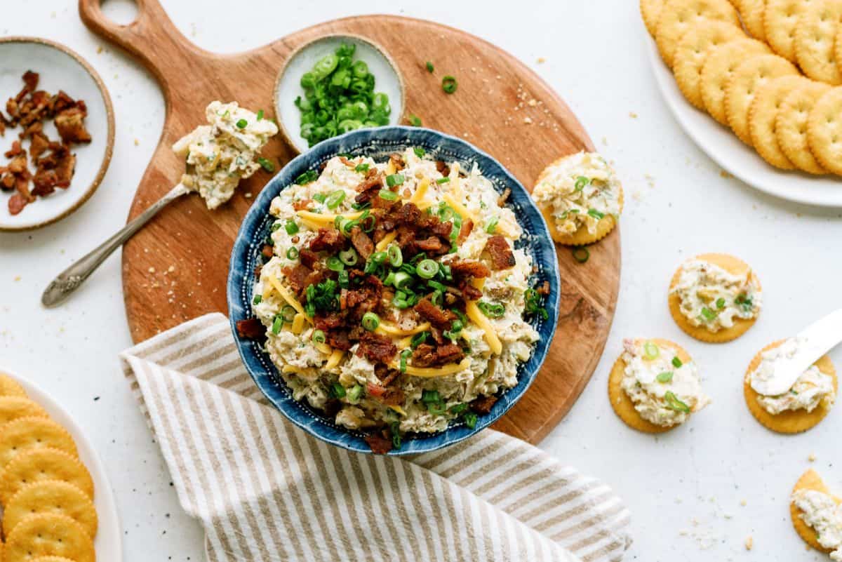 Million Dollar Dip in a bowl with crackers topped with dip around bowl