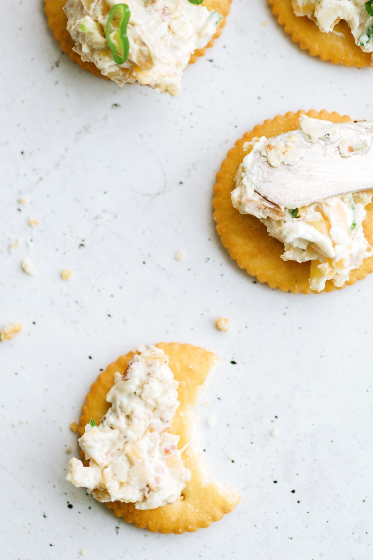 Ritz crackers topped with Million Dollar Dip, once cracker with a bite taken out of it