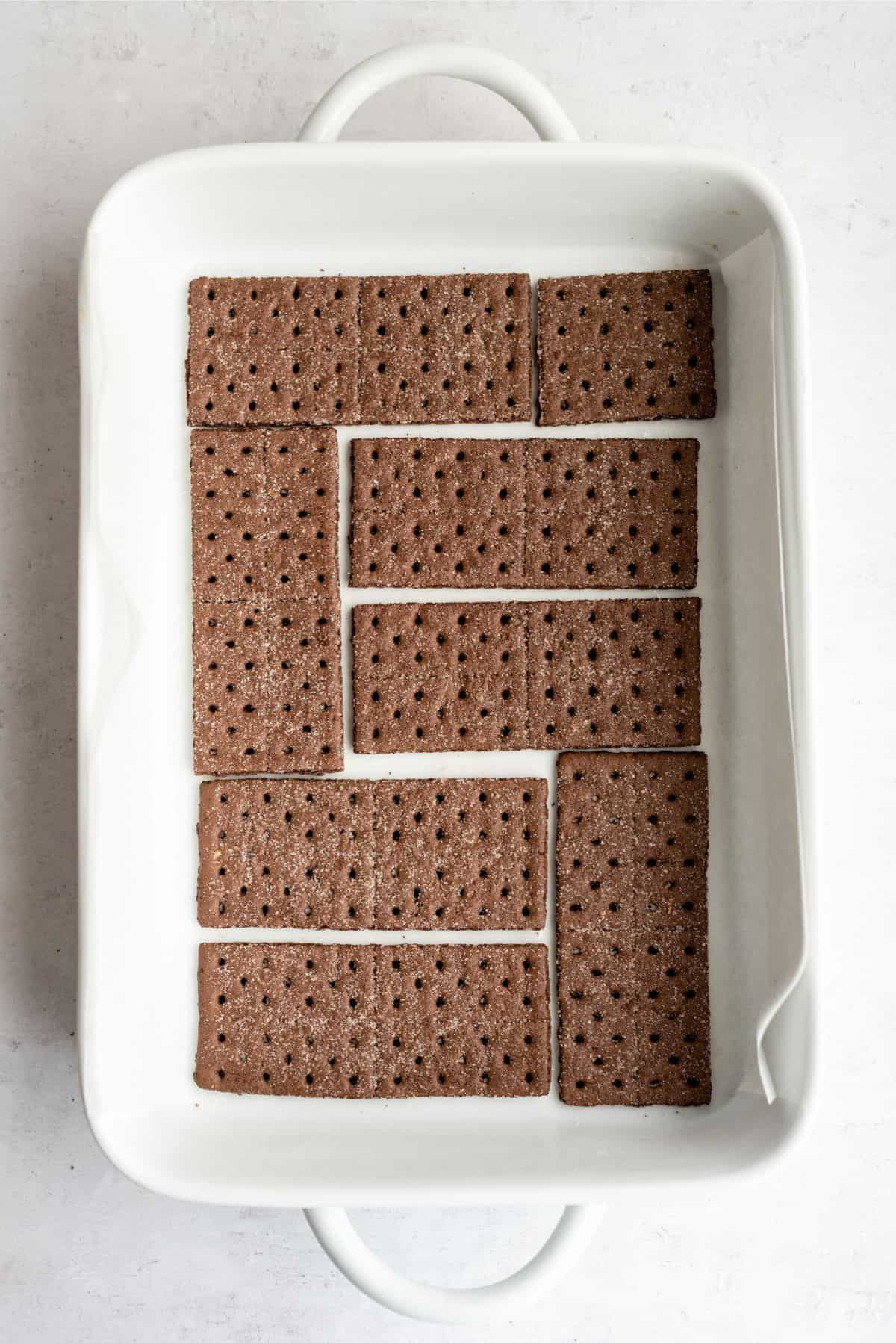 Chocolate graham cracker squares lining the bottom of a baking dish.