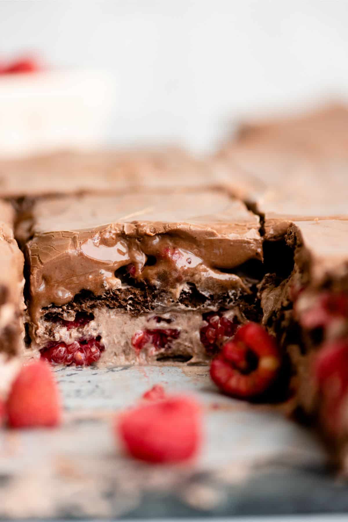 A square of Chocolate Raspberry Eclair Cake inside the baking dish showing the layers of the dessert.