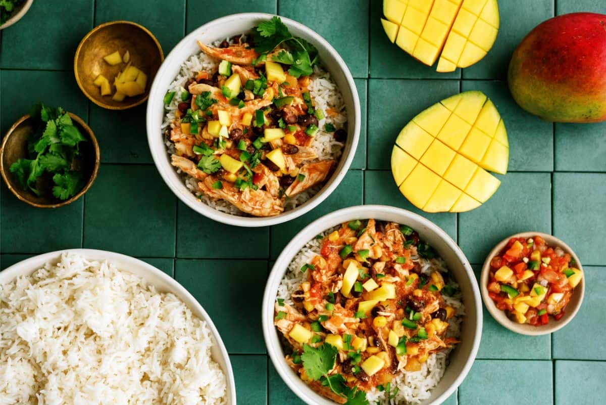 Slow Cooker Mango Chicken in bowls with sides of coconut rice and mango salsa