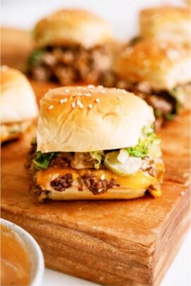 Big Mac Sliders on a cutting board with sauce.