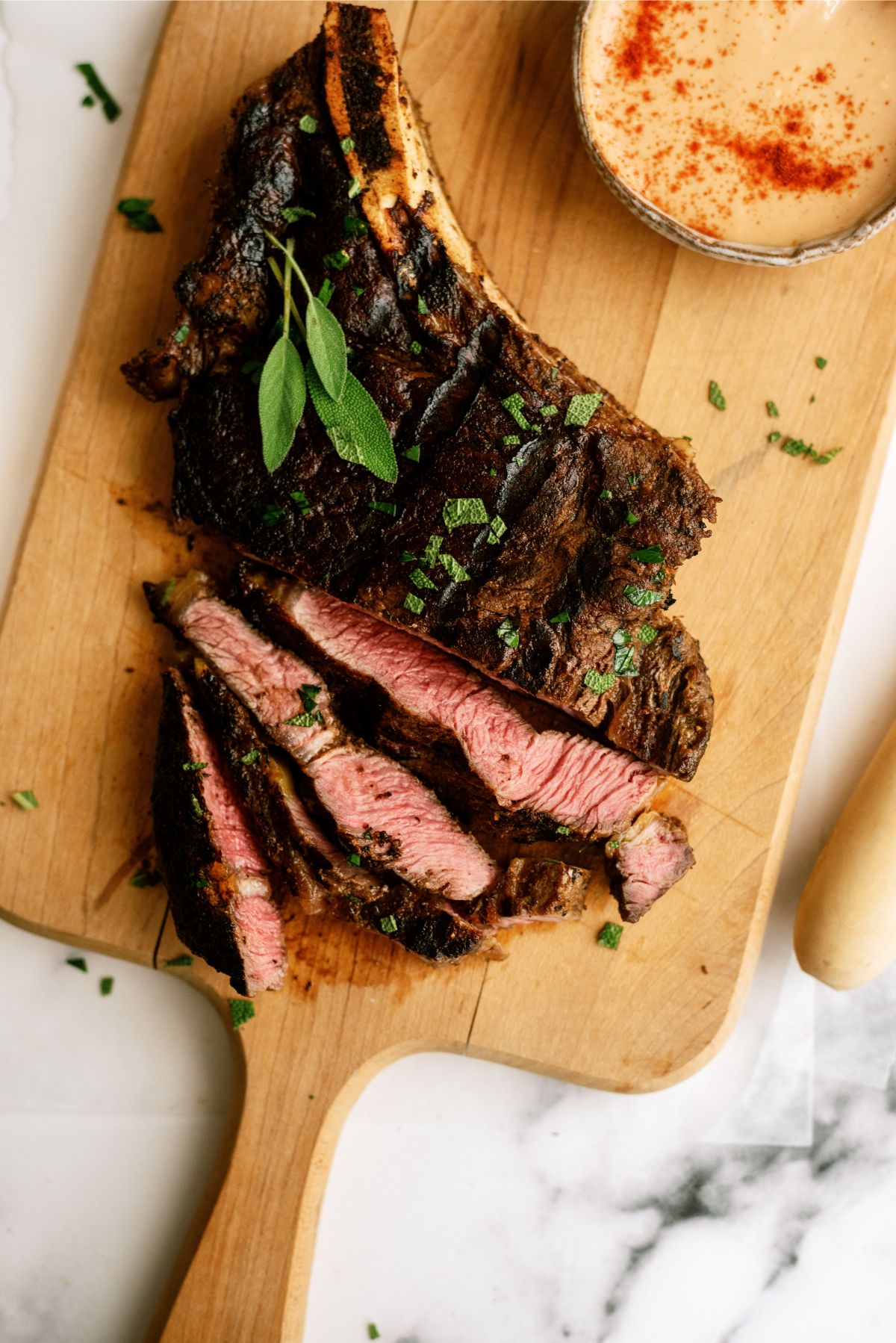 Grilled Ribeye Steak cut into slices on a cutting board