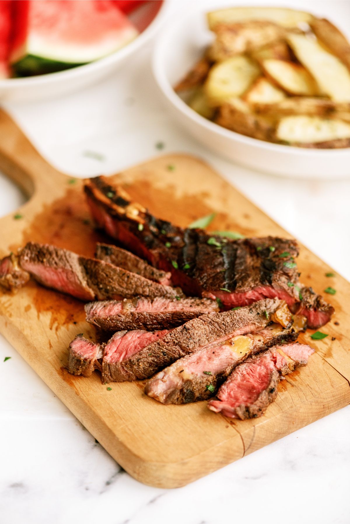 Grilled Ribeye Steak sliced into strips on a cutting board