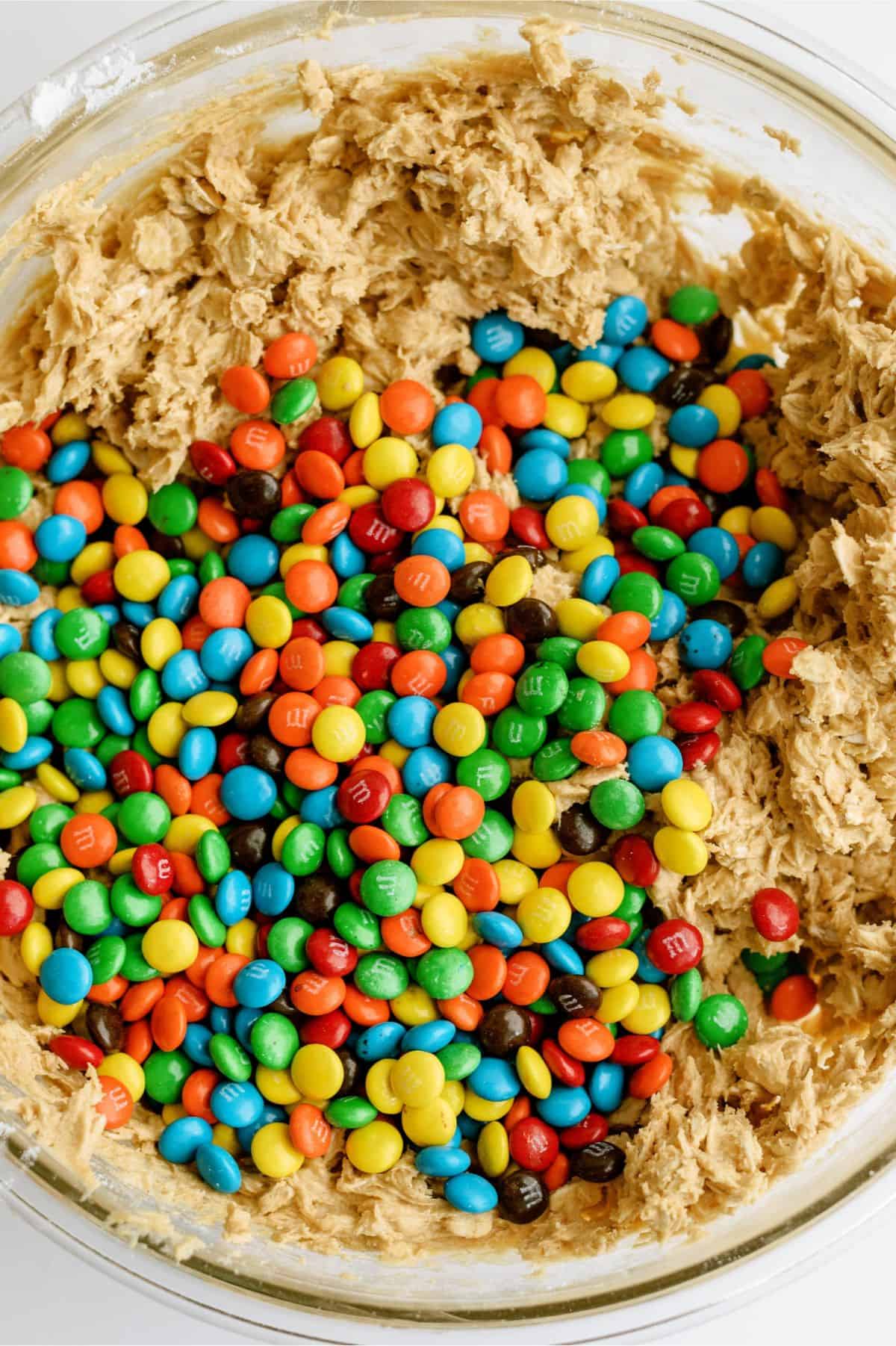 Mini M&M's added to Monster Cookie No Bake Bars dough in mixing bowl.
