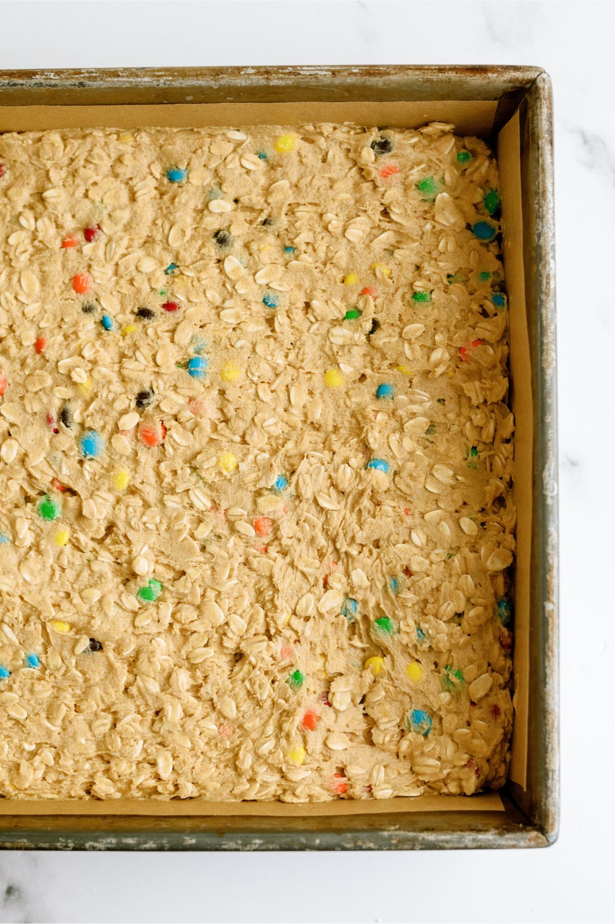 Monster Cookie No Bake Bars pressed into a square pan