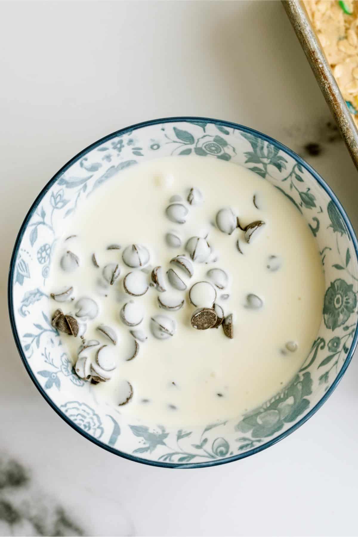 A bowl with chocolate chips and heavy whipping cream.