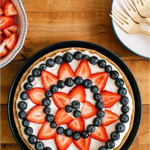Top view of Patriotic Fruit Pizza on a wooden background.