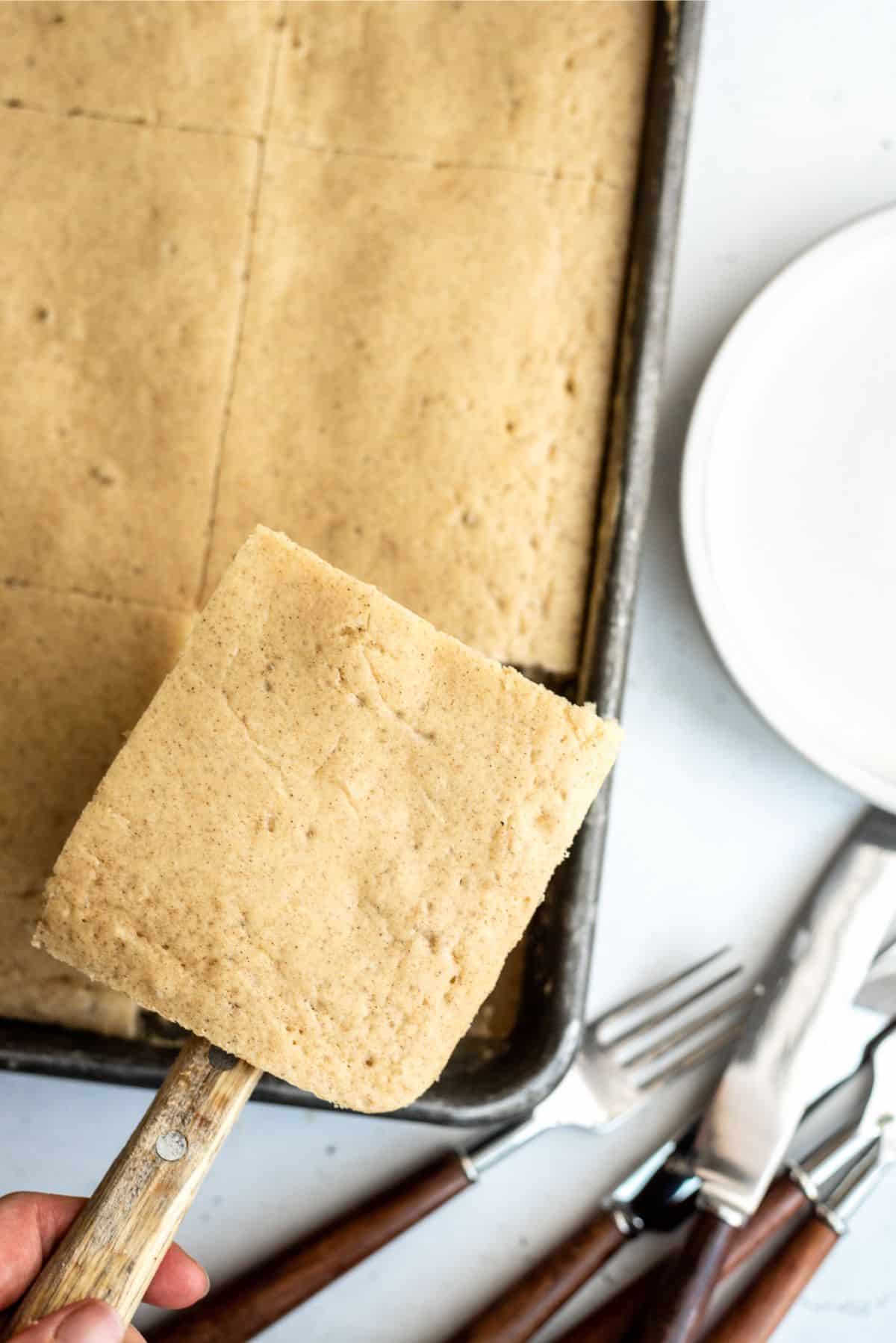 Sheet Pan Pancakes cut into squares in sheet pan with one square lifted out