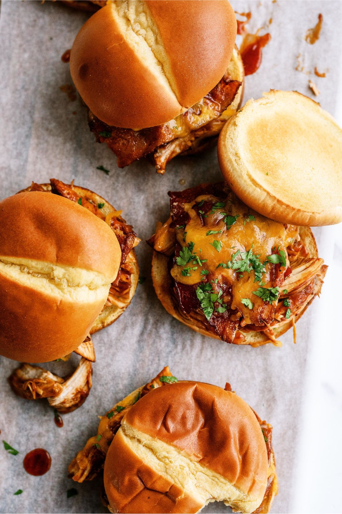 Slow Cooker Cheesy BBQ Chicken Bacon Sandwiches on parchment paper