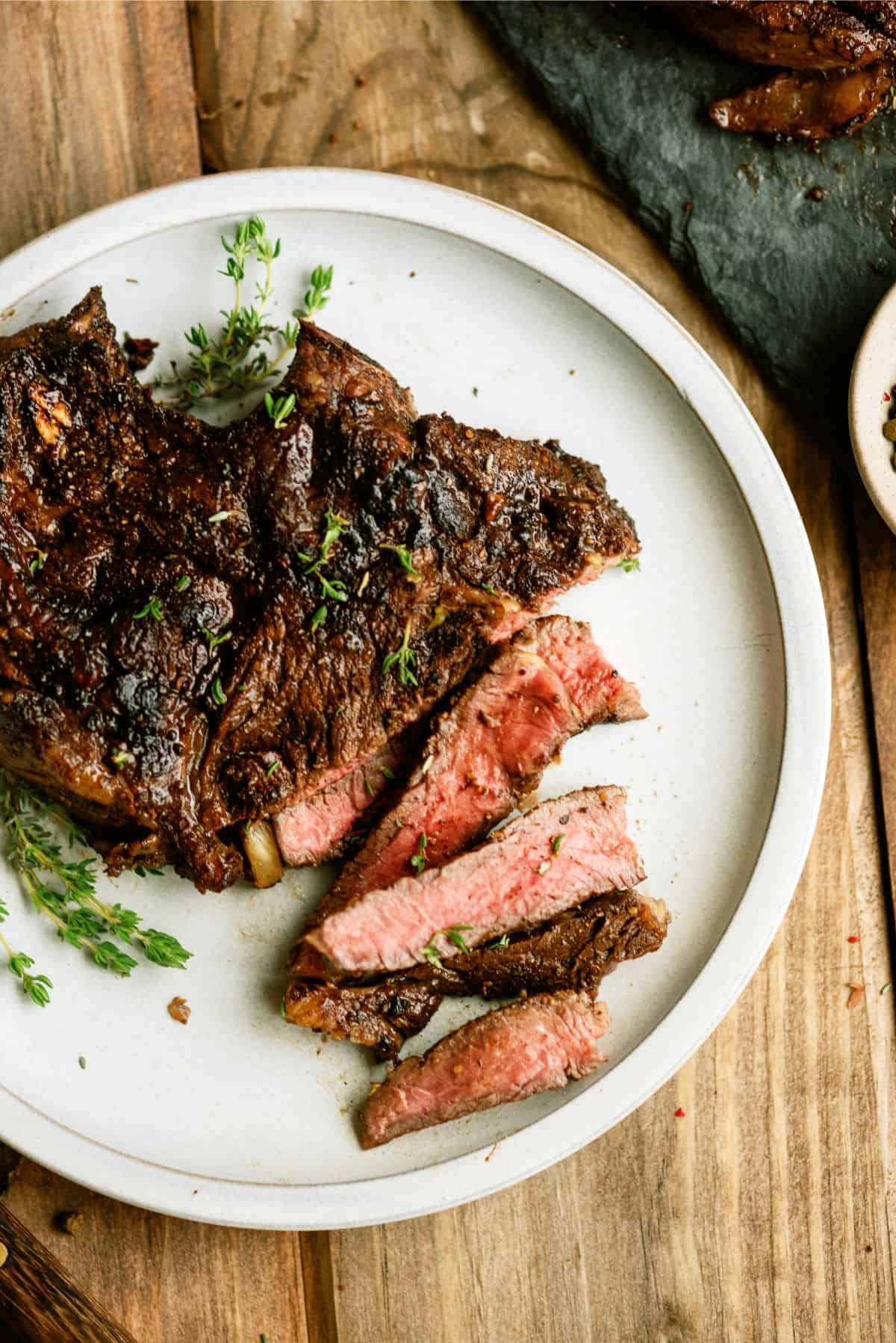 Tangy Marinated Steak on a plate with some pieces cut