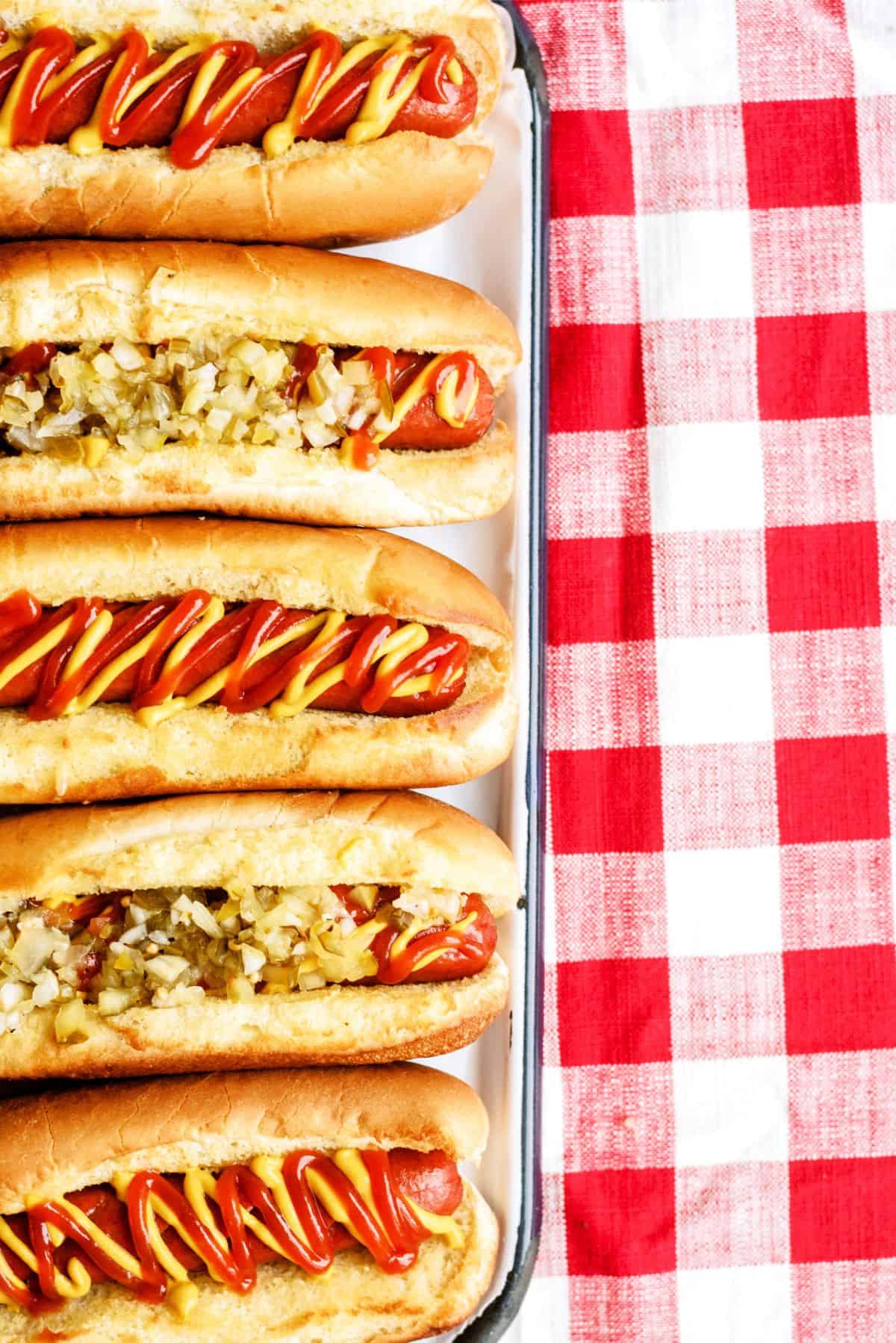 Air Fryer Hot Dogs in buns with toppings on a pan