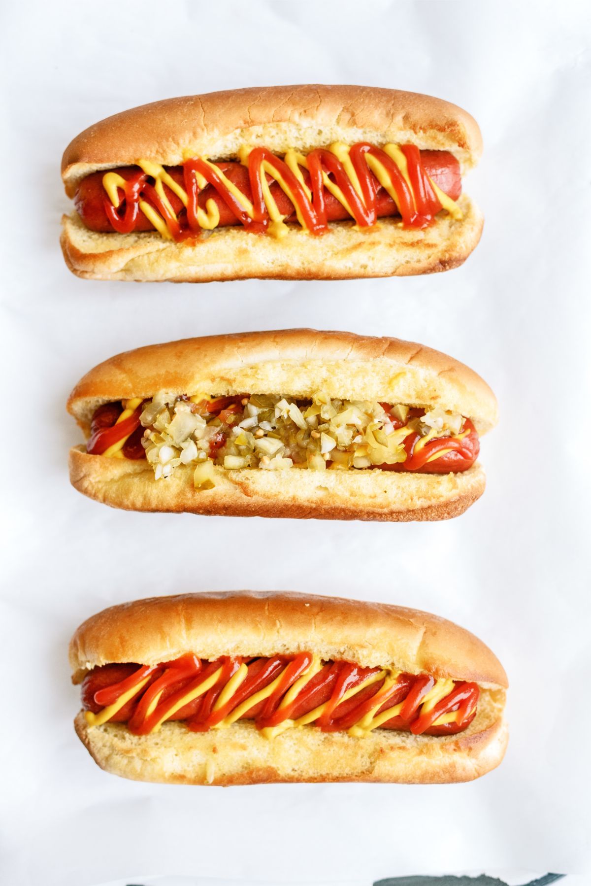 3 Air Fryer Hot Dogs in buns with toppings