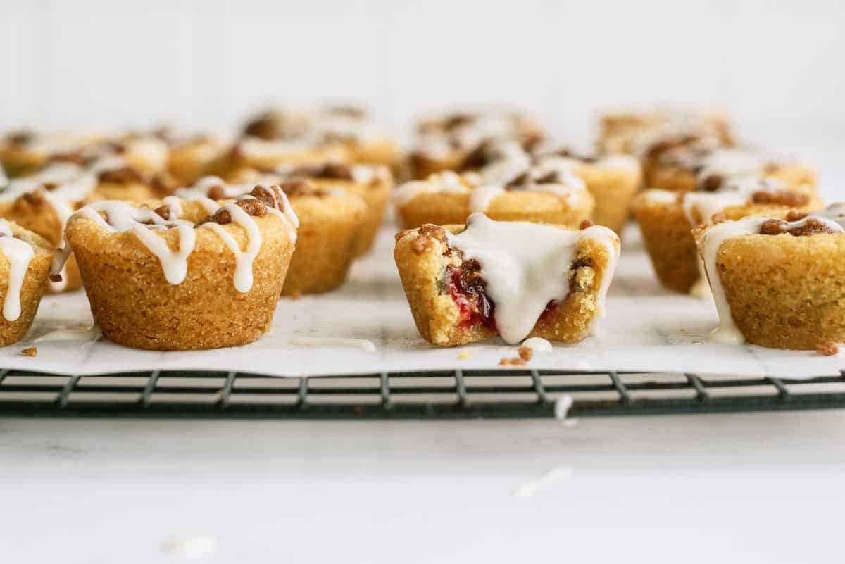 A side view of Cherry Cobbler Cookie Cups with one missing bite to show the inside of the cobbler cup.