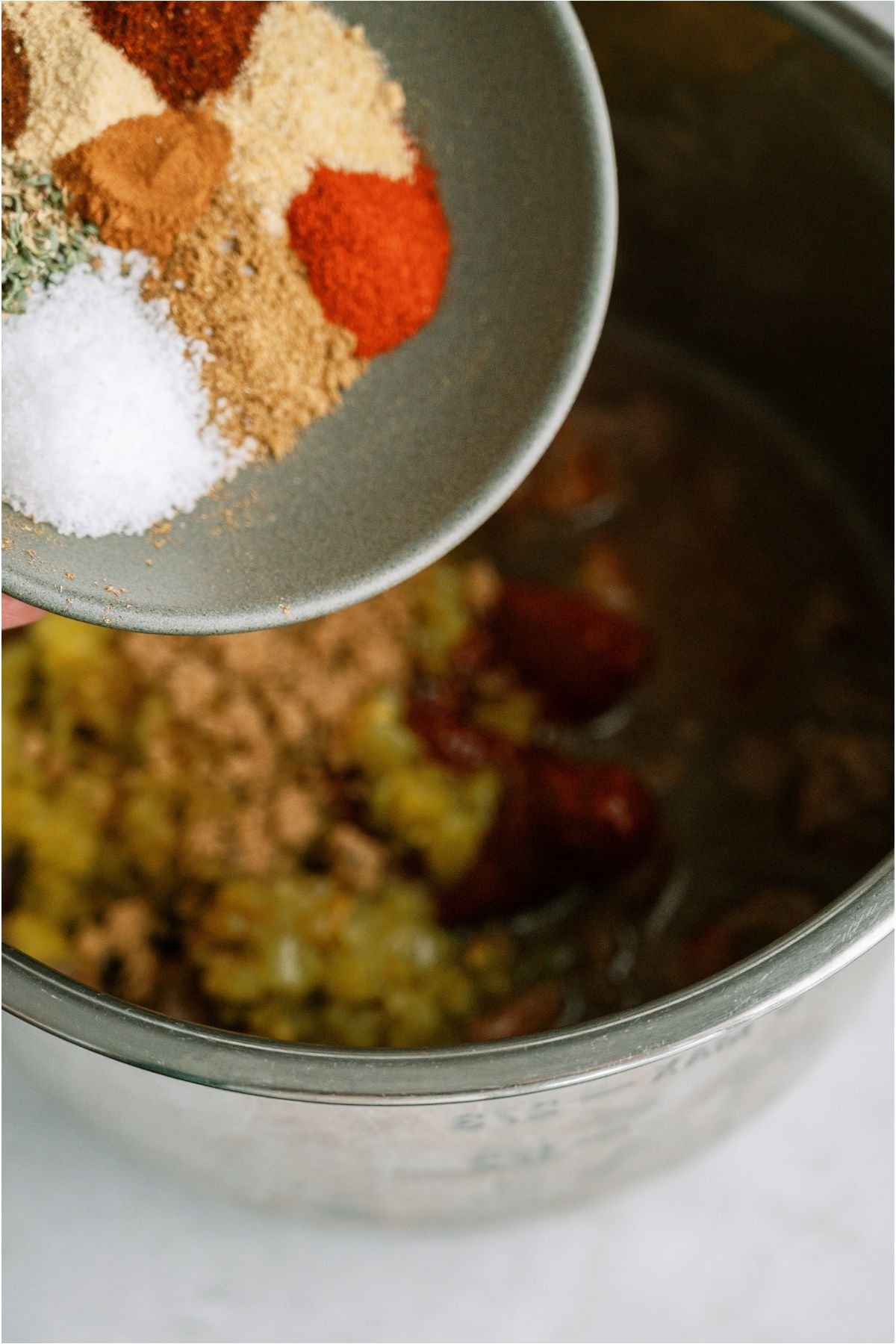 Pouring a bowl of seasonings into the Instant Pot.