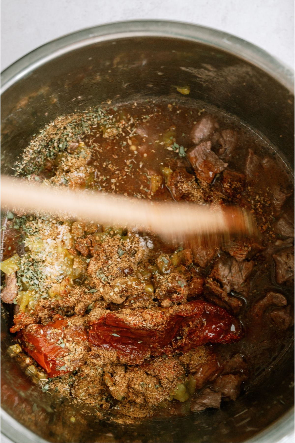 Stirring all the ingredients together in the Instant Pot with a wooden spoon.