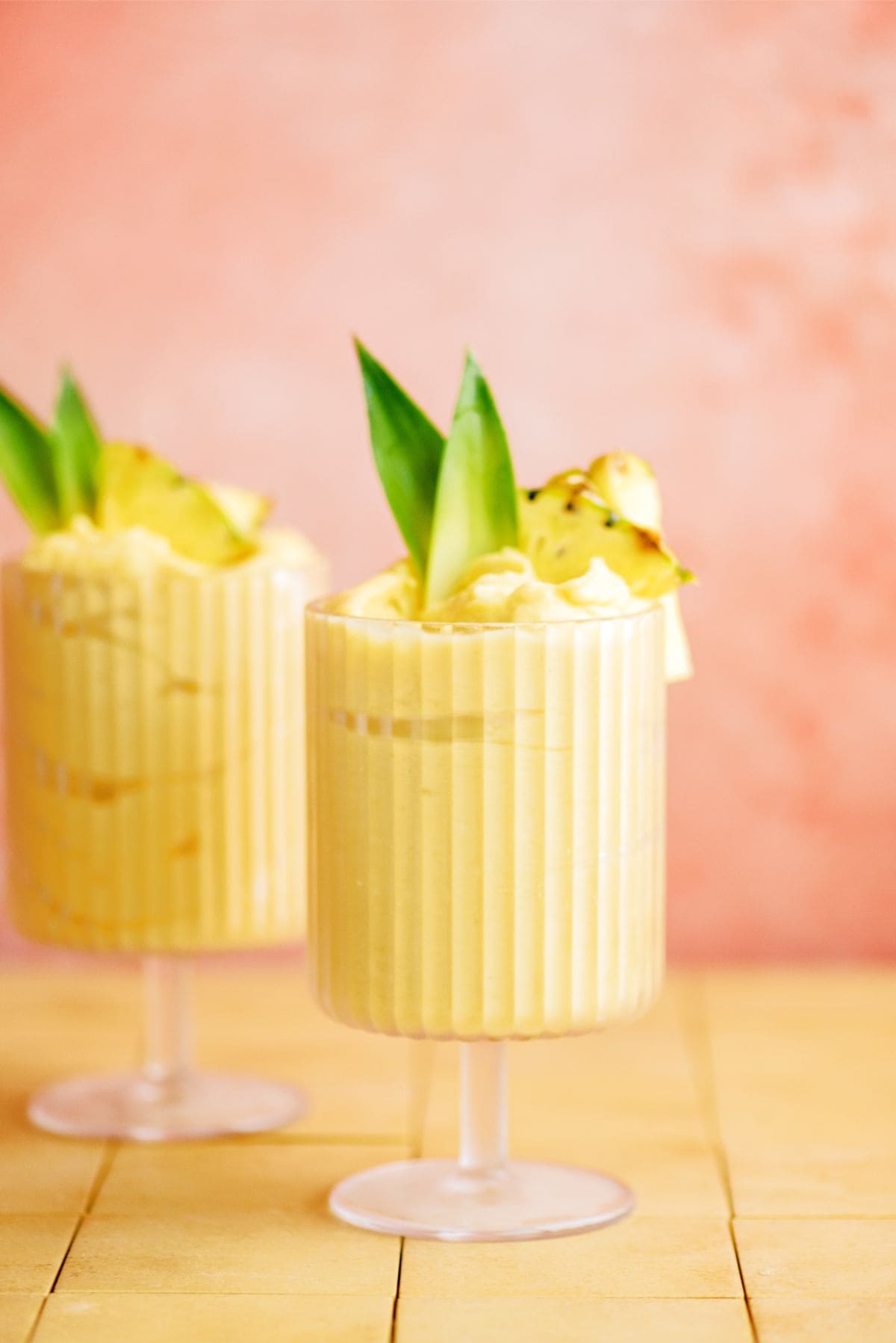 2 Mango and Pineapple Dole Whip in glasses garnished with pineapple