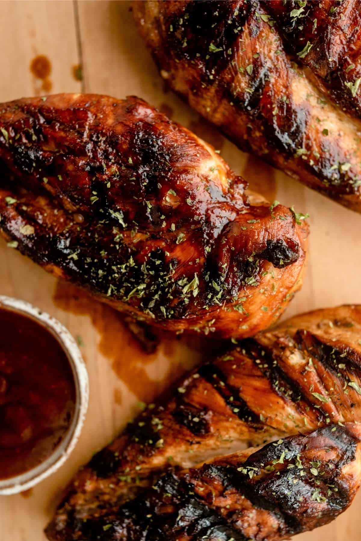 2 pieces of Marinated Root Beer Grilled Chicken  on a cutting board