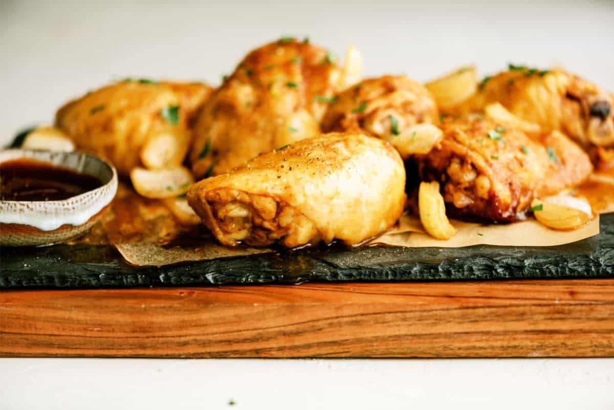 Side view of Slow Cooker BBQ Chicken Thighs on a cutting board