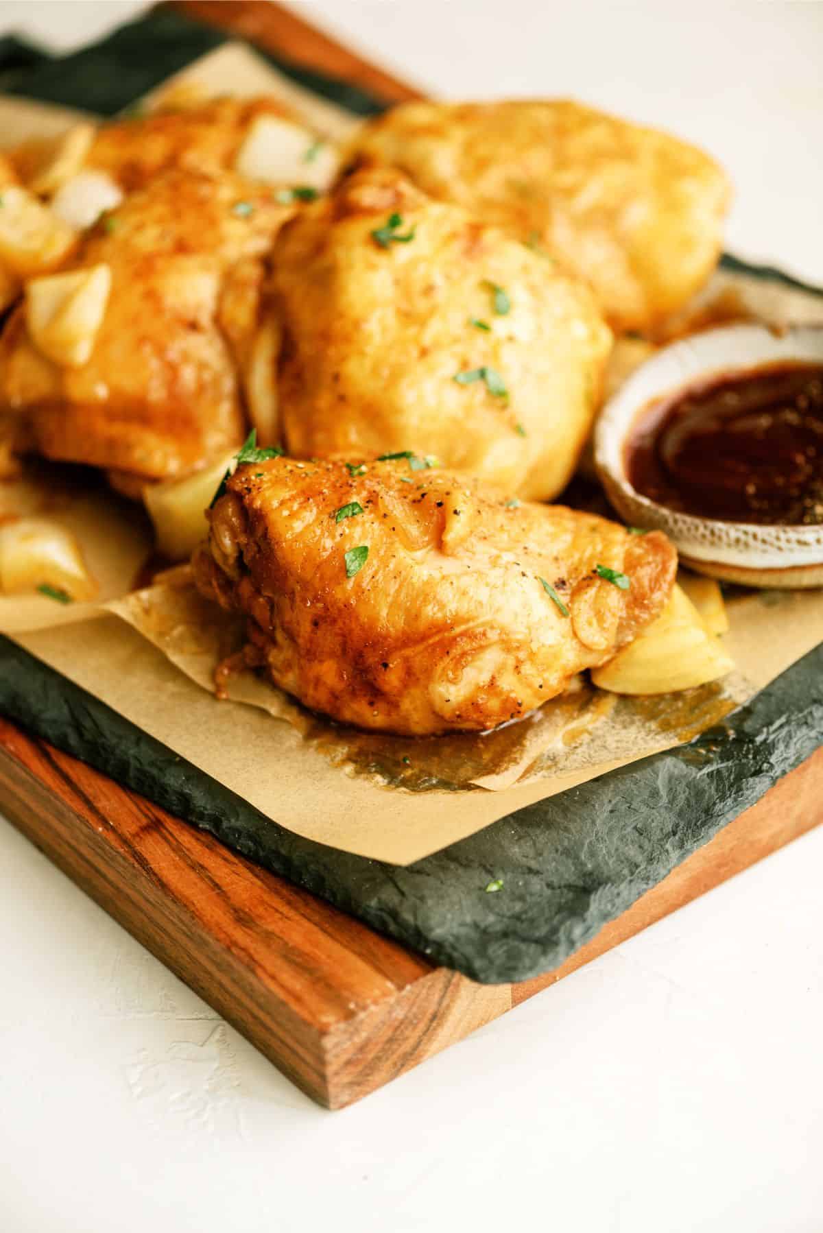 Slow Cooker BBQ Chicken Thighs with a side of BBQ sauce 