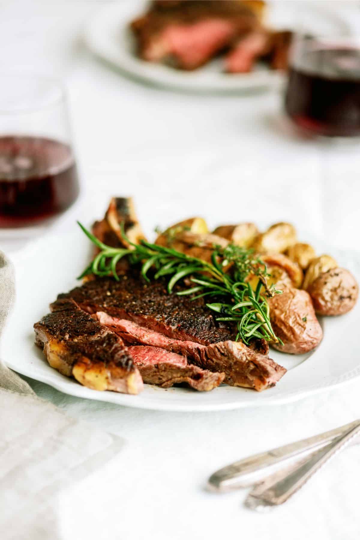 New York Bone In Steak on a plate with potatoes