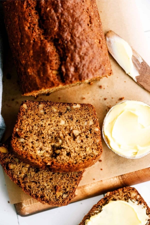 sliced banana bread on cutting board with butter