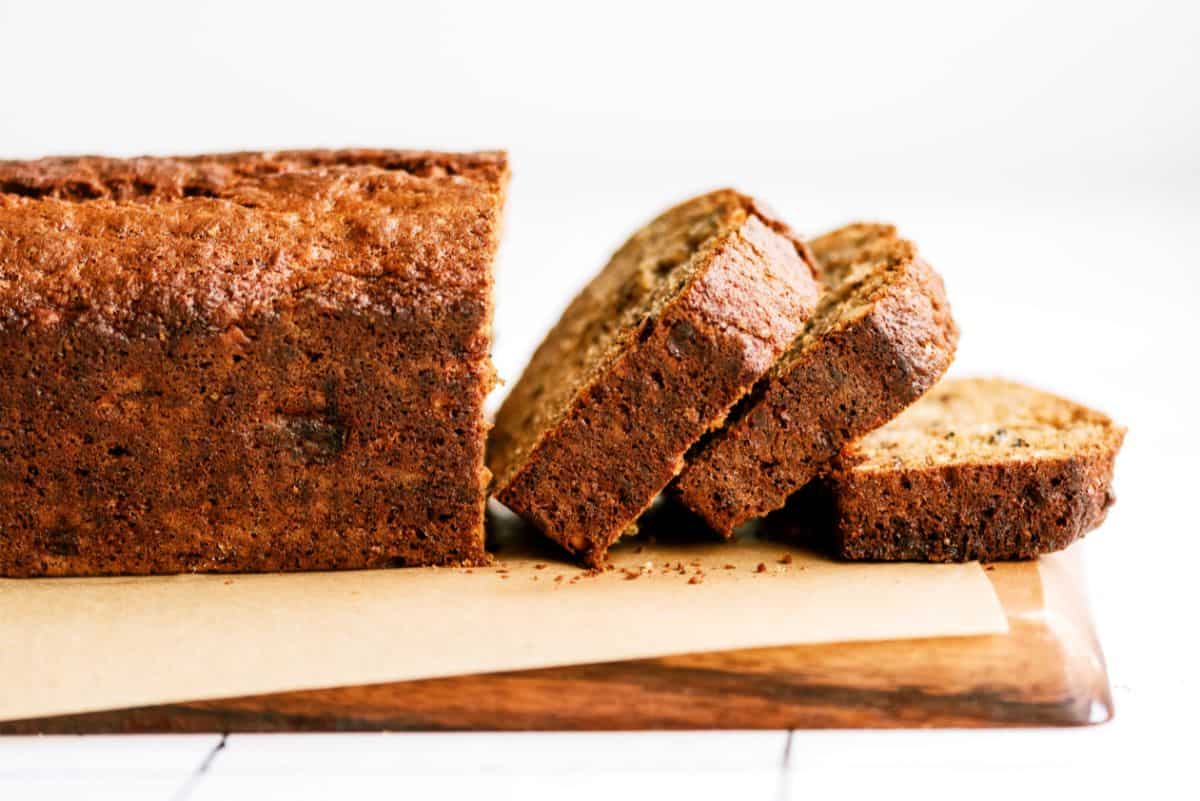 Loaf of banana bread sliced on a cutting board