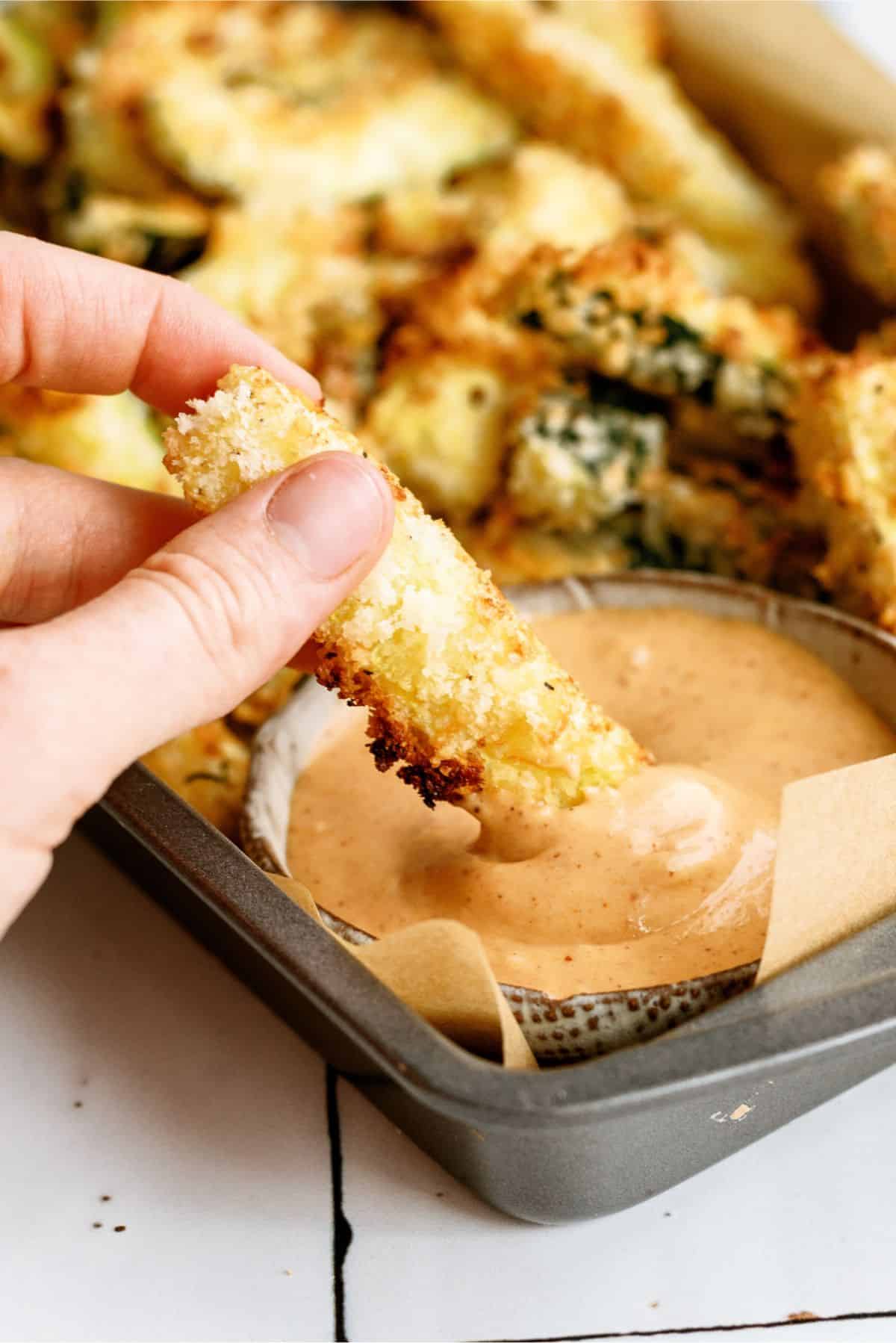 Dipping Crispy Zucchini Fry in creamy BBQ Sauce