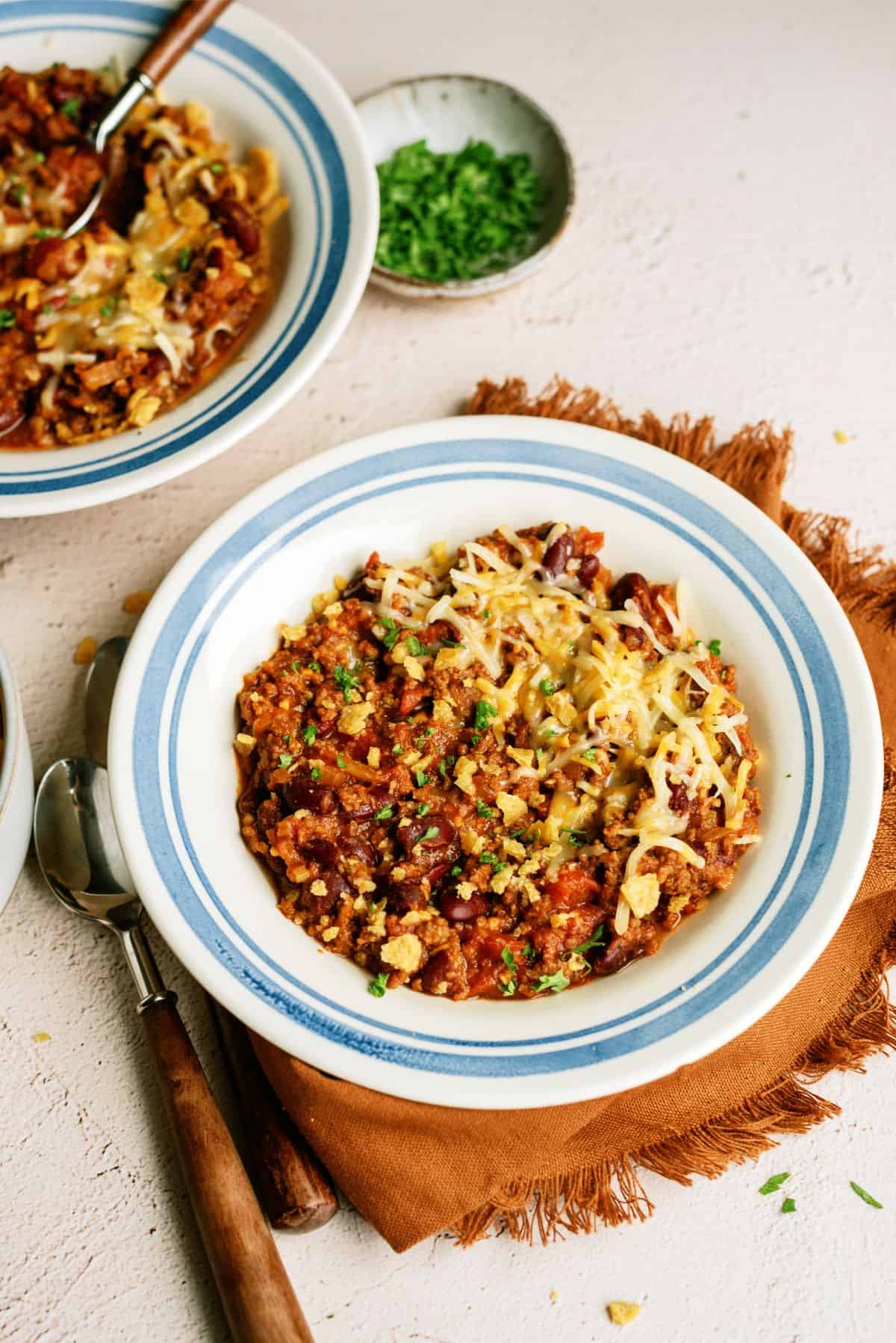 2 bowls of Mom's Slow Cooker Chili with toppings