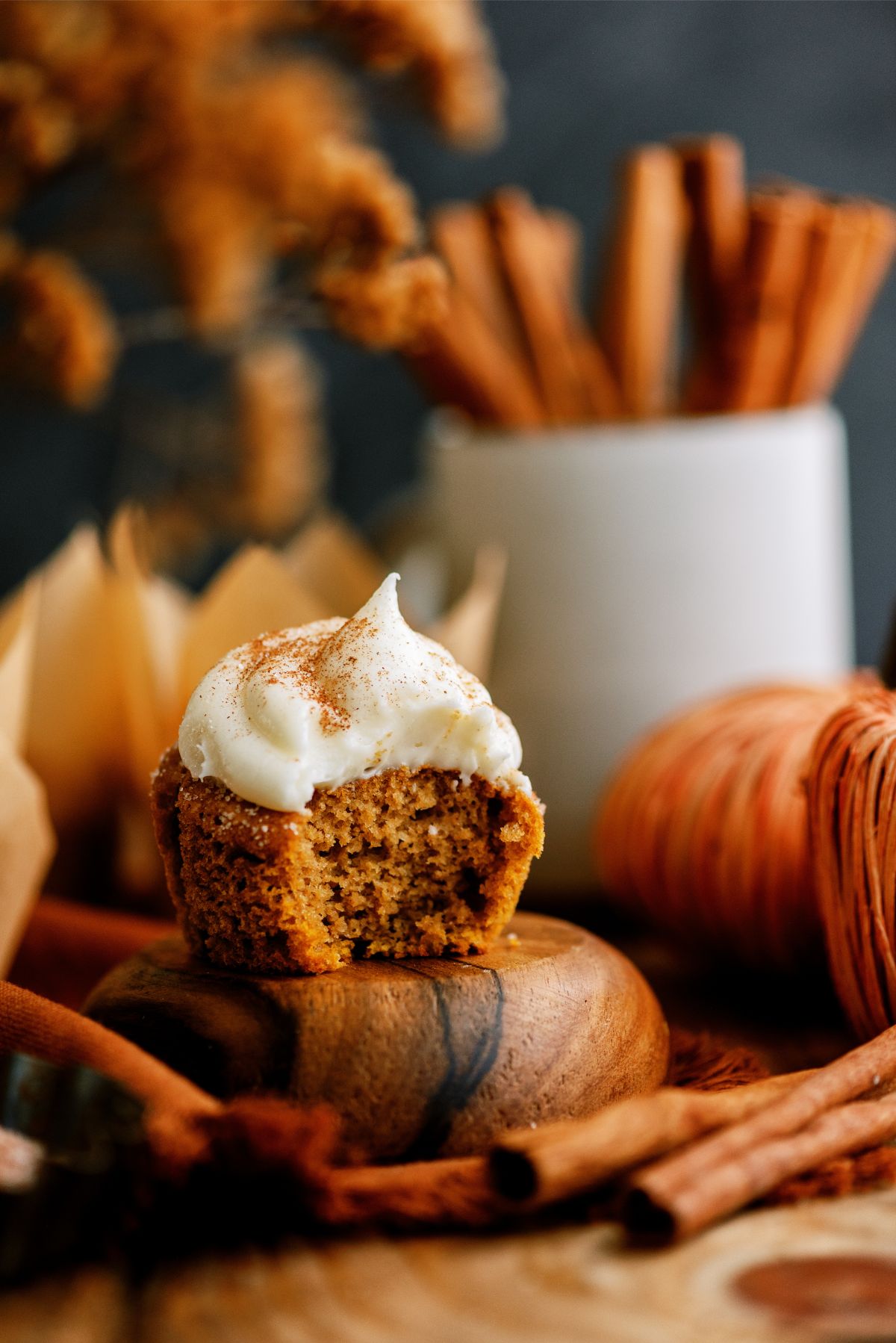 Pumpkin Cupcake topped with cream cheese frosting with a bite missing