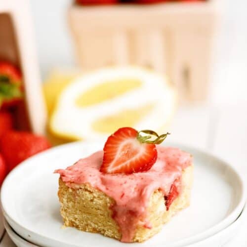 A strawberry lemon blondie on a plate with strawberries.