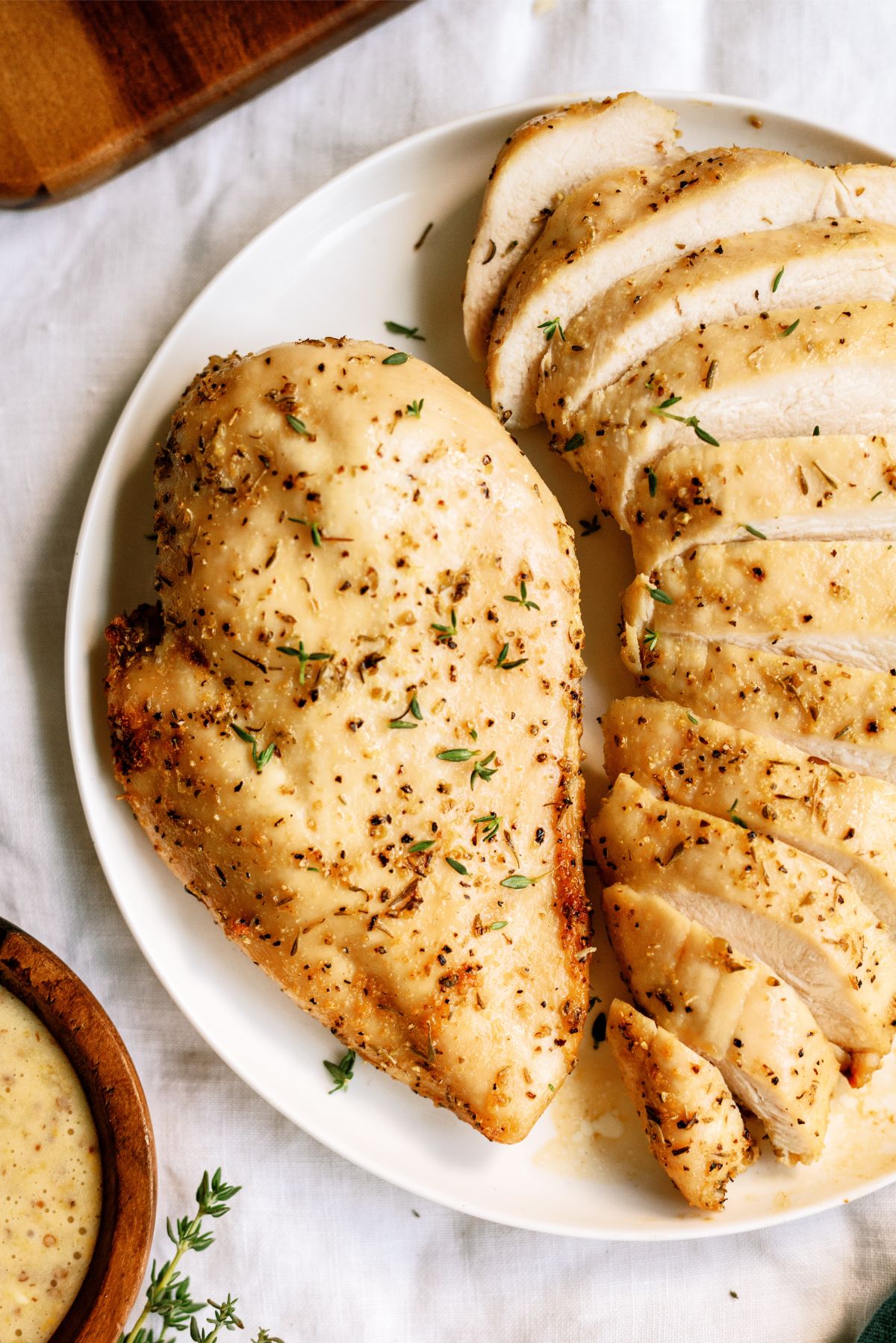 Baked Chicken Breast on a serving plate with one chicken breast sliced