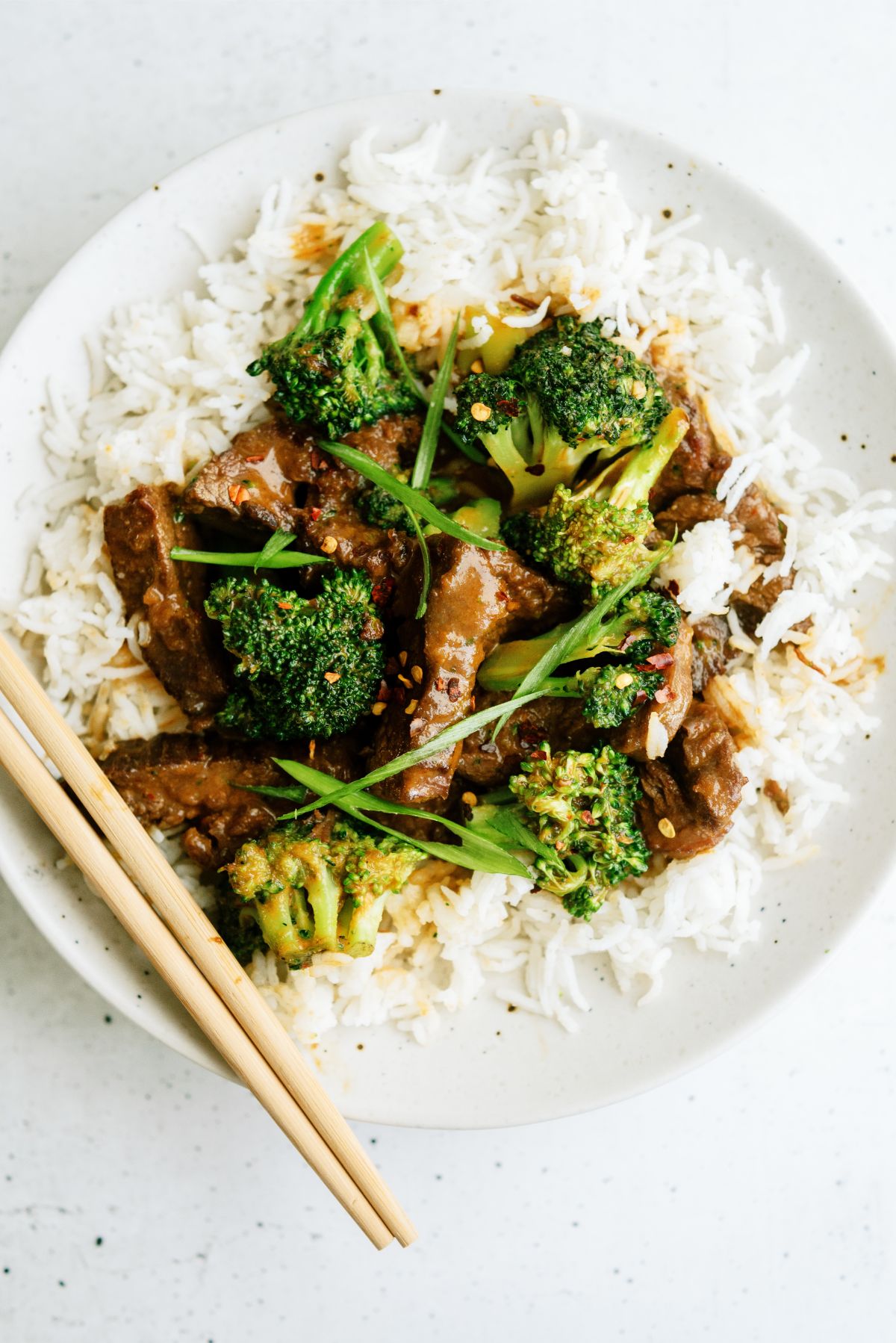 Beef and Broccoli served over rice with chop sticks