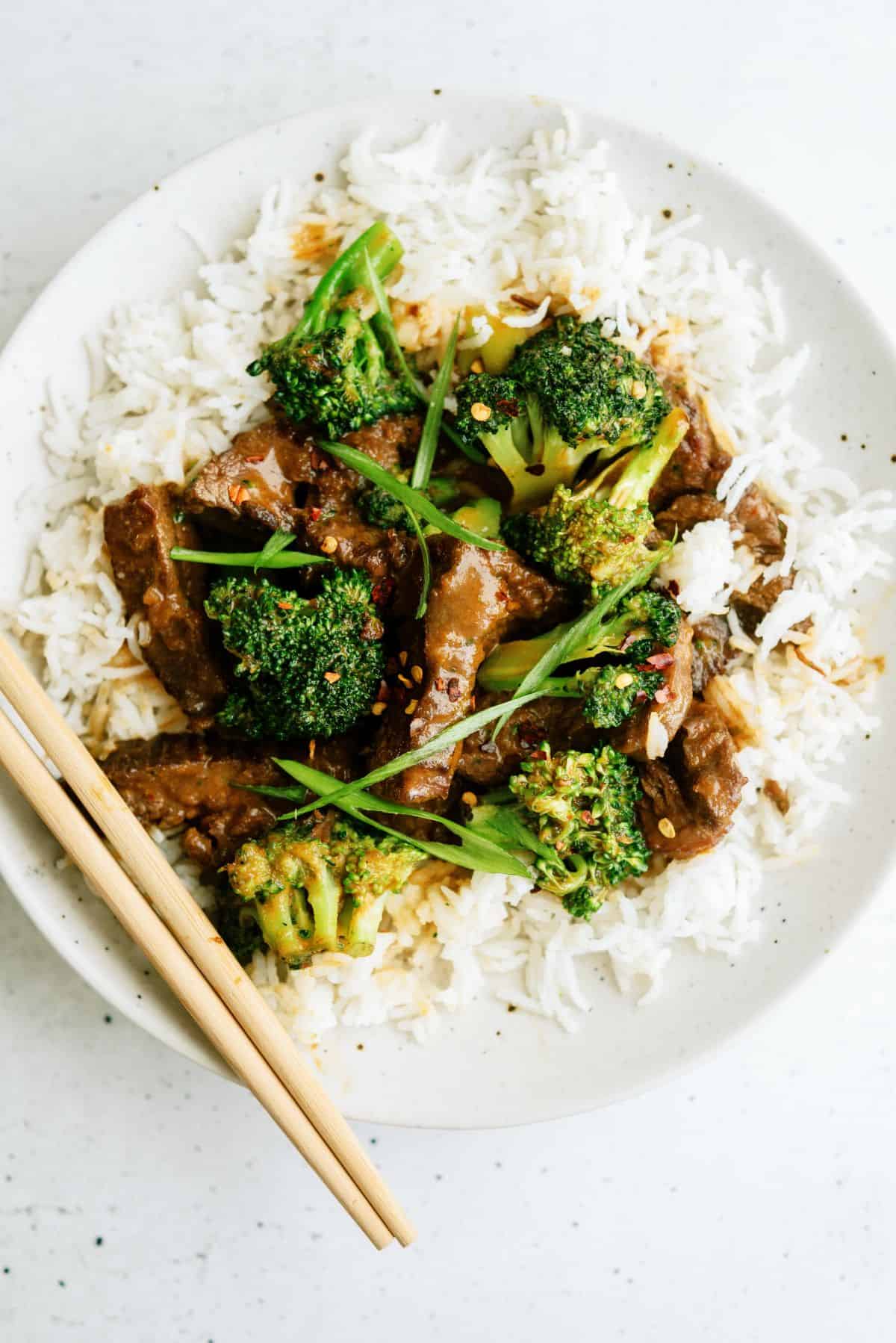 Beef and Broccoli served over rice with chop sticks