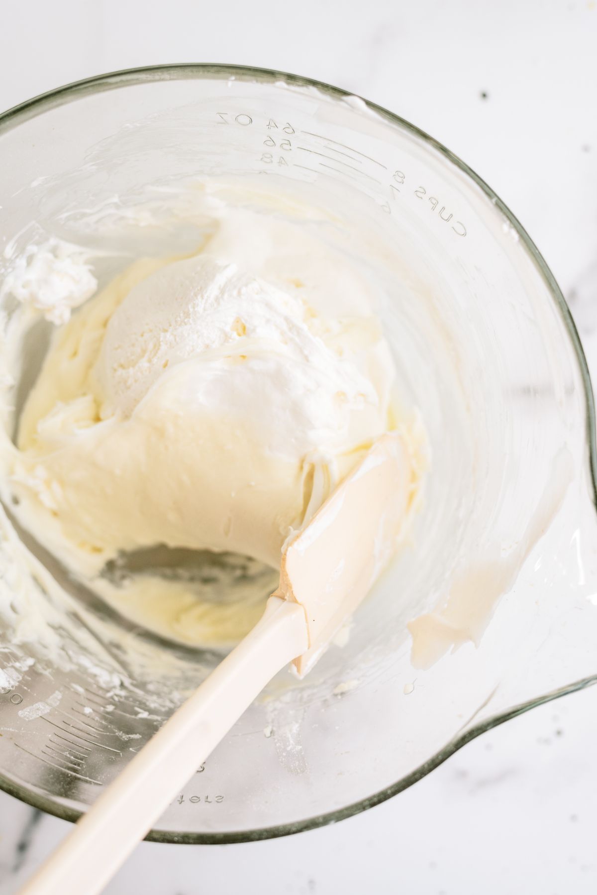 Folding whip cream into the cream cheese layer ingredients in a bowl