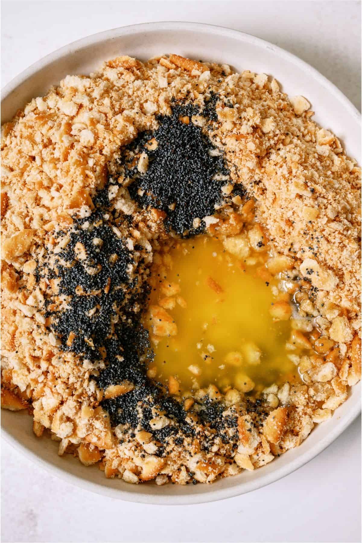 Ritz crackers, poppy seeds and butter in a mixing bowl.
