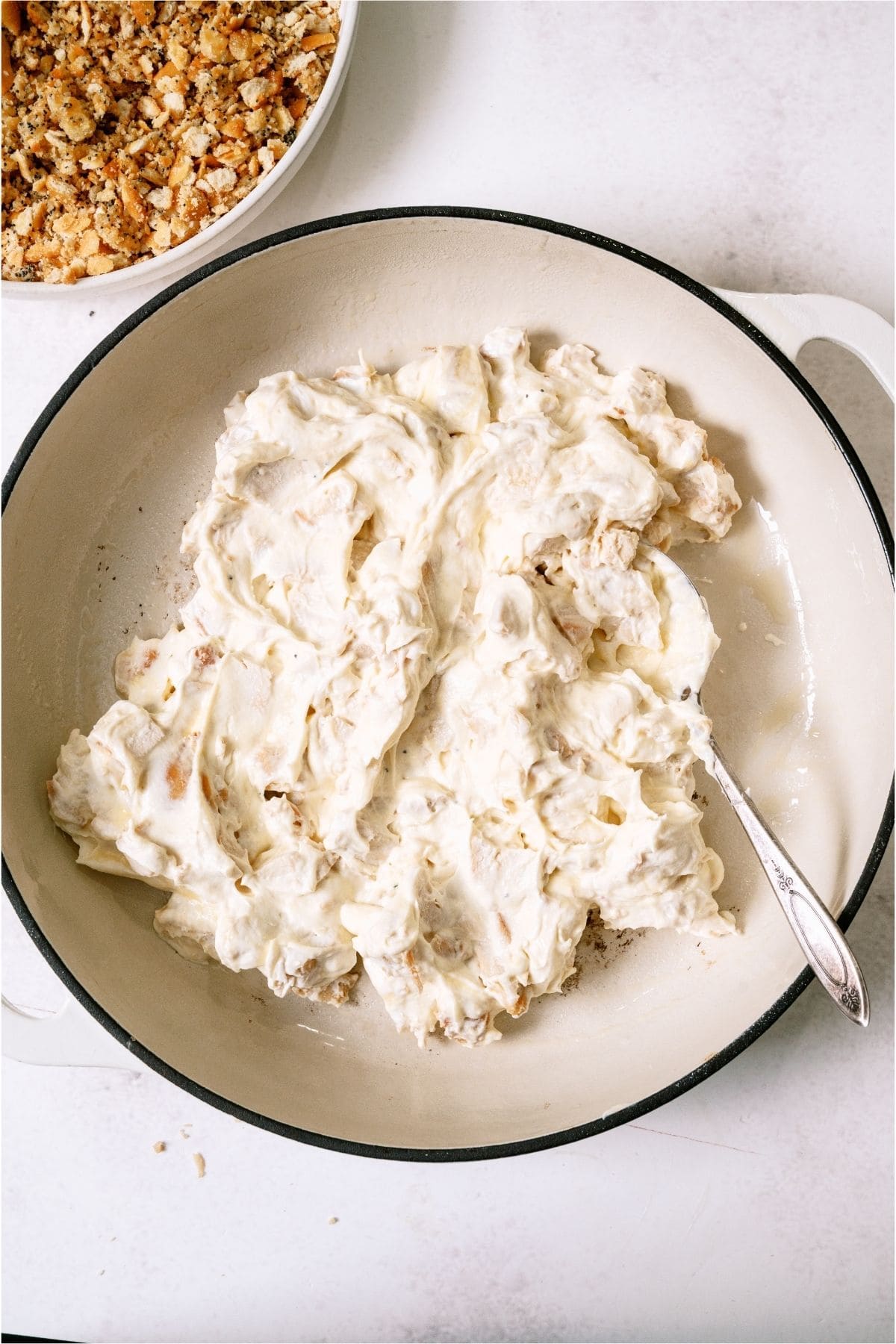 Sour cream chicken mixture spread in a casserole dish.