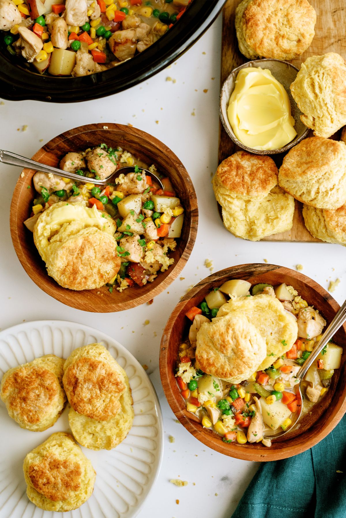 2 bowls of Slow Cooker Chicken Pot Pie with biscuits in the background.